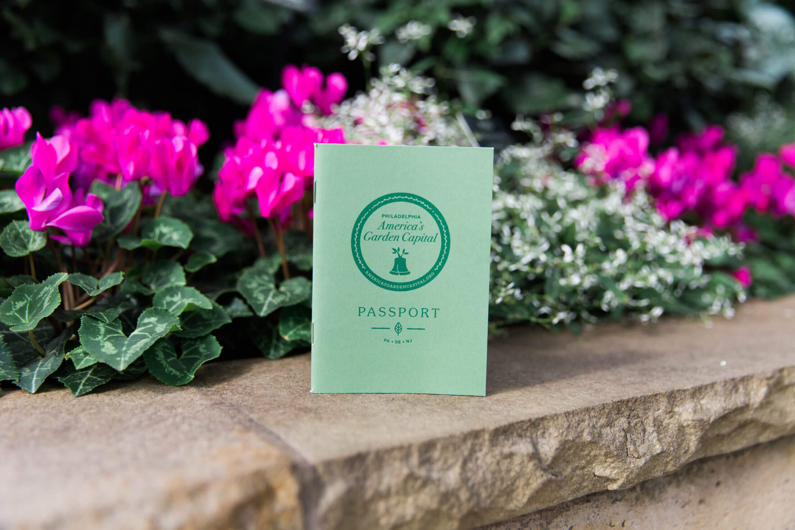 A pamphlet from American's Garden Capital in front of a bed of flowers