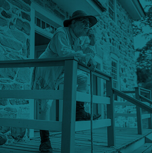 Historical reenactor in colonial attire standing on a porch Hover