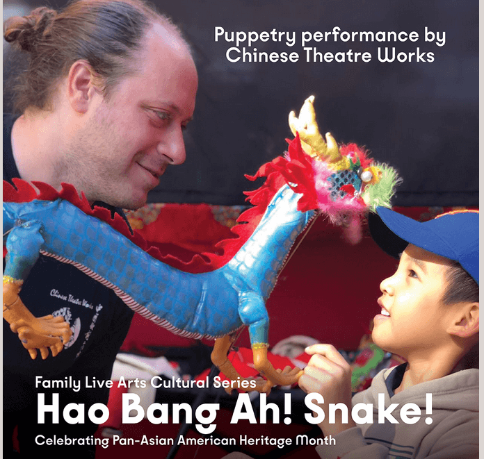 Performer and child interacting with colorful dragon puppet at Hao Bang Ah! Snake show.
