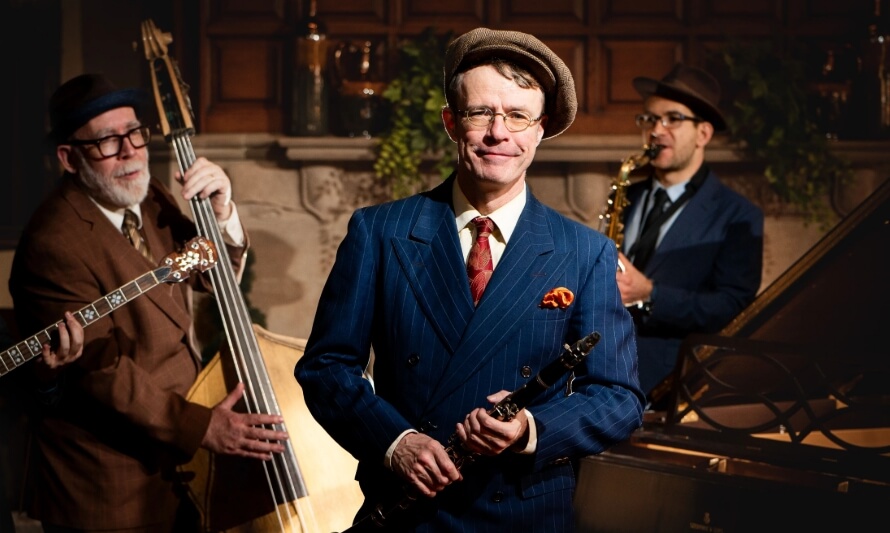 Jazz band musicians performing, with clarinetist in front, bassist, and saxophonist in background