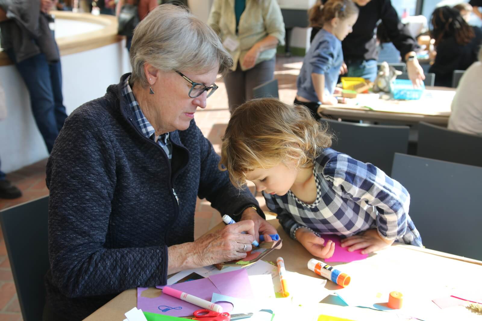 Older woman and child doing an art project together at a table.